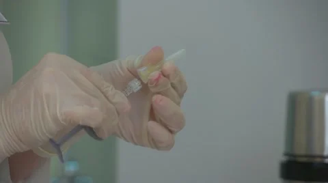 Hands with sterile gloves holding a hypodermic needle Stock Footage 57673063