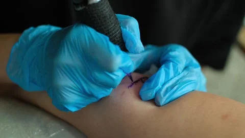 Hands in sterile latex gloves holding rotor tattoo machine. Professional tattoo Stock Footage 252133575