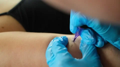 Hands in sterile latex gloves holding rotor tattoo machine. Professional tattoo Stock Footage 252133583