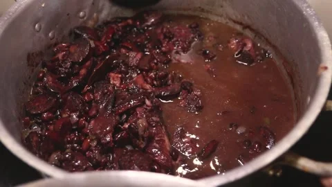 Hands stirring pan with brazilian feijoada Stock Footage 265257996