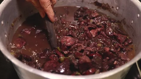 Hands stirring a pan with feijoada, typical Brazilian food Stock Footage 265258005