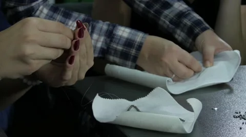 Hands stitching decorative elements on cloth, sewing with needle, close up, 4K Stock Footage 55850784