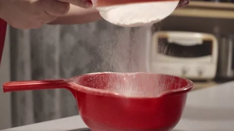 Hands straining flour into a strainer Stock Footage 132844116