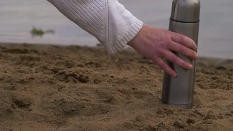 Hands with straw hat and thermos flask on beach Stock Footage 169014335