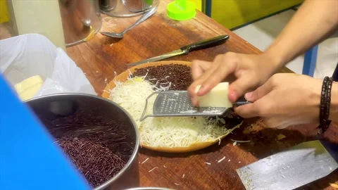 Hands of street vendor grating cheese on indonesian sweet thick pancake Stock-Footage 334948894