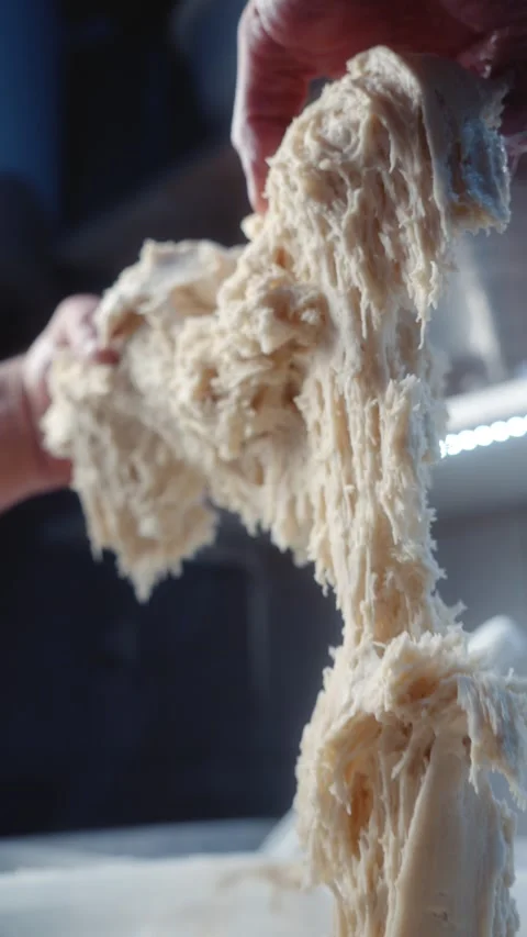 Hands stretching elastic bread dough Stock Footage 344313131