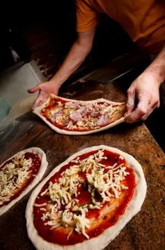 Hands stretching the pizza. Stock Photos
