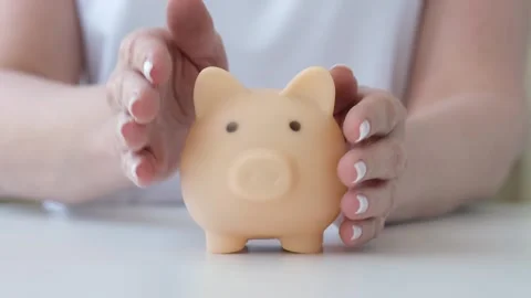 Hands stroking and protecting piggy bank. Money accumulation and insurance Video stock 285361644