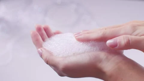 Hands stroking shampoo foam, close-up shot on a fir background, beautiful 스톡 동영상 258321593