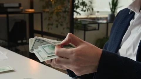 Hands of Successful Businessman Holding Stack of Dollar Bills Sitting at Desk Stock Footage 331535929