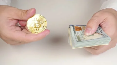 Hands of a successful young man in a white shirt hold a golden bitcoin Stock Footage 165597249