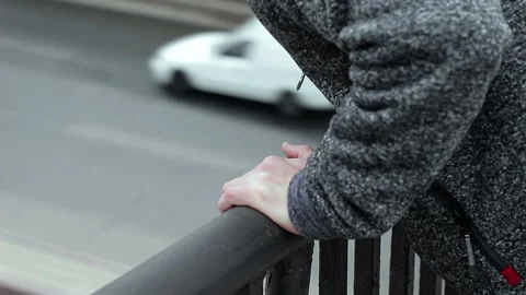 Hands of a suicide man on a bridge on a background of traffic cars 動画素材 88886336