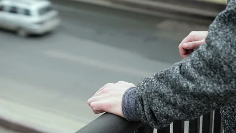 The hands of a suicide on the railing of the bridge against of road traffic Stock Footage 100647336