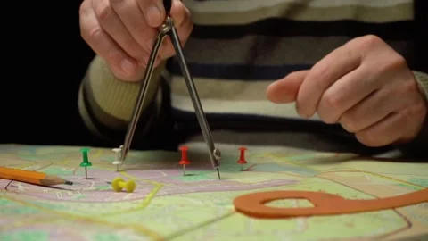 Hands of a surveyor using a compass to measure distances on a map with colorful Stock Footage 332866821