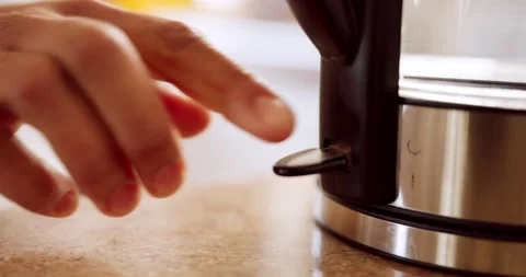 Hands switch on kettle, kitchen appliance and water boiler for cooking food, tea Stock Footage 212345606