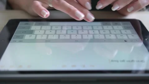 Hands on the tablet's digital keyboard, close-up. A girl is typing a text. Stock Footage 303622290