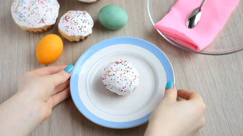Hands take away from the table a plate with a Easter cake with white icing. Stock Footage 61638409