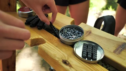 Hands take bullets for an air rifle. Preparing for shooting Stock Footage 164989488