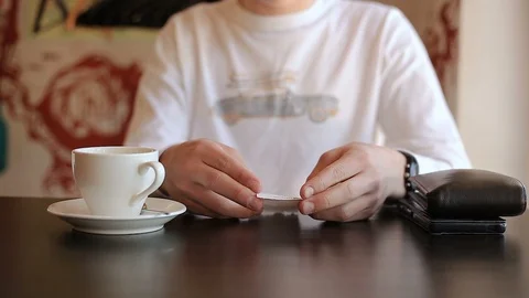 Hands take the check, wallet from the table in the cafe and the guy leaves Vidéo 113671865