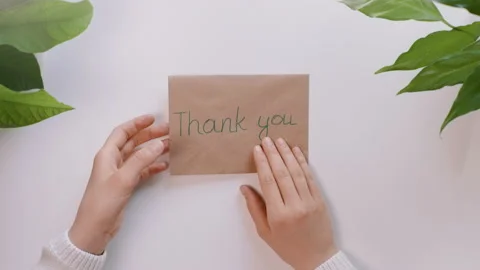 Hands take a craft envelope with the words Thank you and take out dollars. Stock Footage 130906210