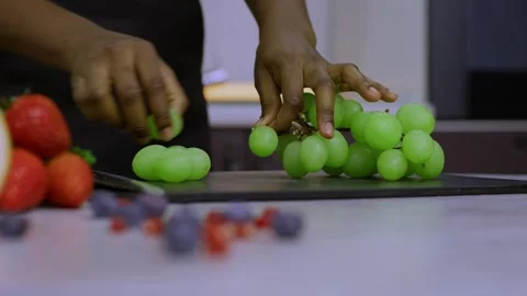 Hands take the grapes and begin to tear the grapes from the bunch to prepare a Видео 269895825