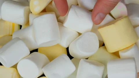 Hands take multicolored mini marshmallow candies on the mirror surface and a Stock Footage 104688195