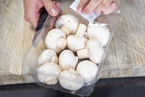 Hands take mushroom from a pack close-up. The process of drying mushrooms. Stock Photos