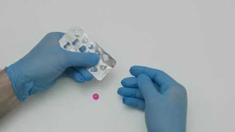 Hands take out pink tablet from blister Stock Footage 321745423