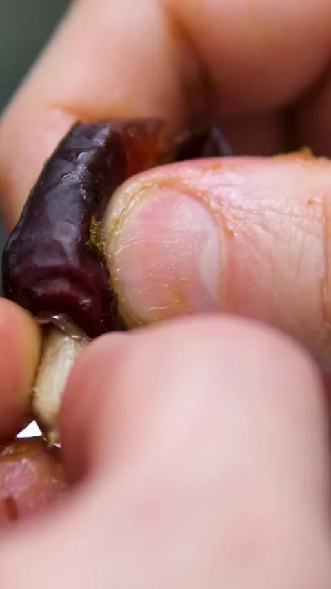 Hands take the pit out of the fruit dried date slow motion of date fruits Stock Footage 308811240