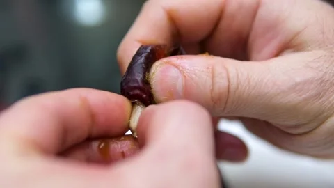 Hands take the pit out of the fruit dried date slow motion of date fruits Stock Footage 308811294
