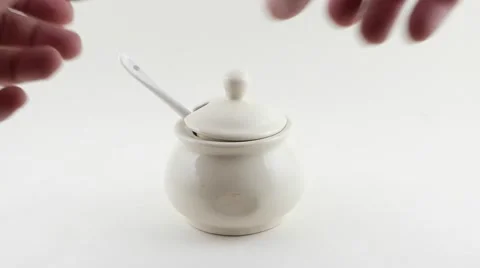 Hands take a spoon full of sugar from a ceramic sugar pot and back Stock Footage 68769686