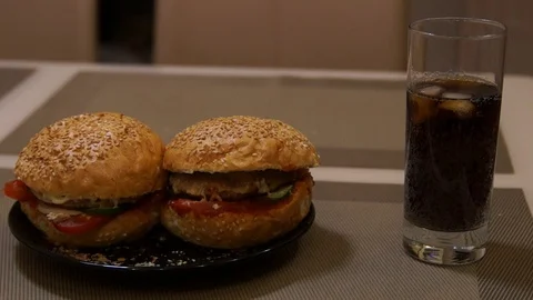 Hands takes a burger. Man eats burger. Fast food. Junk food. Burger and cola Stock Footage 97112061