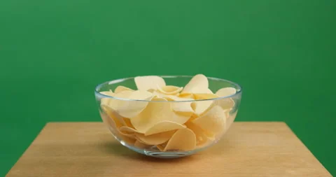 Hands takes the chips from the bowl Stockbeeldmateriaal 154132969