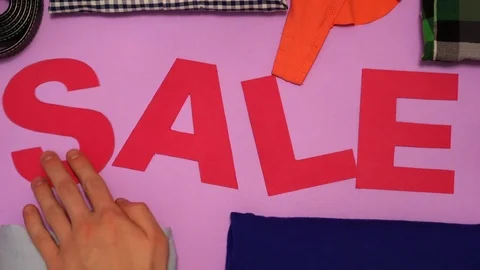 The hands takes clothes, and under it is an inscription of a sale Video stock 83467407