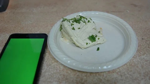 Hands takes hummus with bread from plastic plate, cell phone with chromakey. Vídeos de archivo 99766449