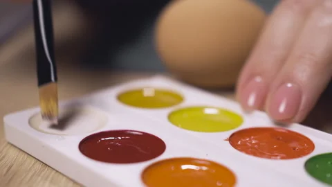 Hands takes white paint for coloring easter eggs with painting brush. Stock Footage 329068398