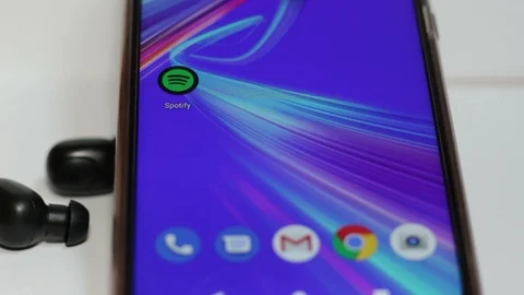 Hands taking bluetooth earphones to listen to music on the Spotify app Stock Footage 126592302