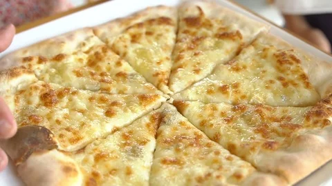 Hands taking cheese pizza cuts from small plate Stock Footage 77578527