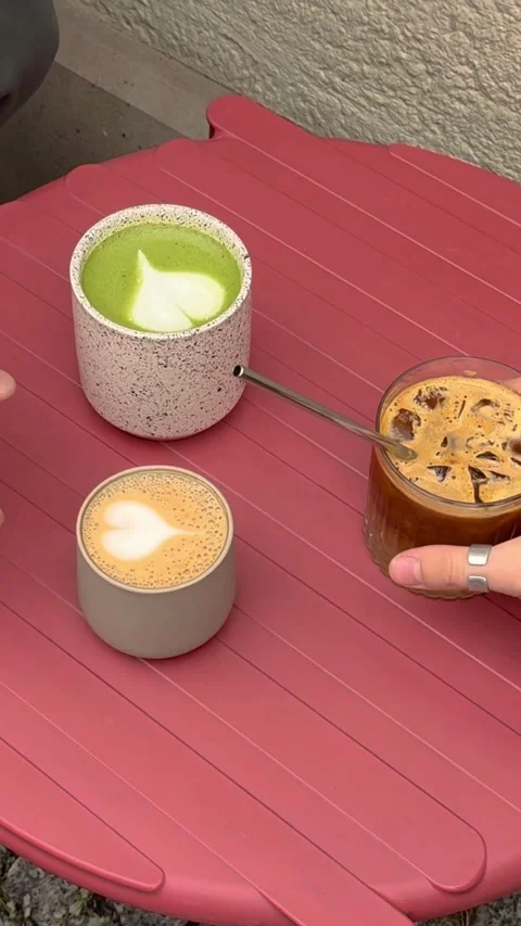 Hands taking coffee cups from pink outdoor bistro table Video stock 331772605