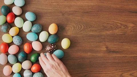 Hands Taking colorful Easter eggs of wooden table. Easter holiday decorations Video stock 124383515
