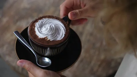 Hands taking a cup of dairy free cappuccino with cream on top. Video stock 149796348