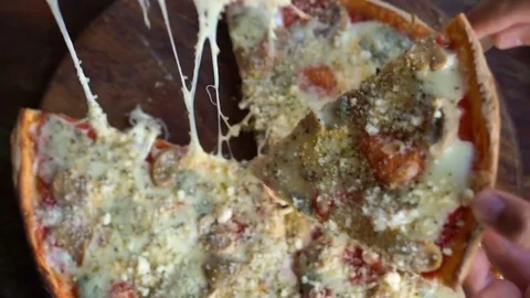 Hands taking homemade pizza slice from plate on wood table Stock-Footage 72169343