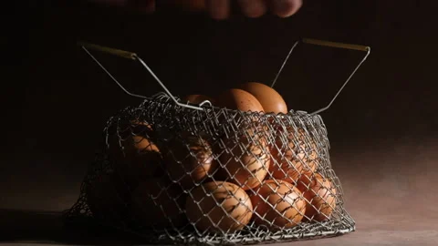 Hands taking out chicken eggs out of metal mesh wire egg basket. Stock Footage 148121703