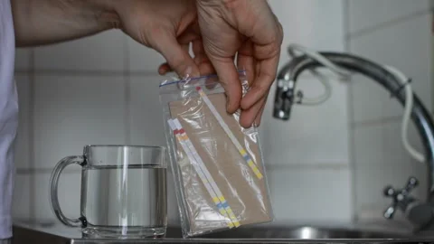 Hands taking out simple test strip from package for water quality analysis Stock Footage 329214034