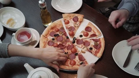 Hands taking pizza cuts Top view, close-up shot. In a cafe, communication and Stock Footage 74807114