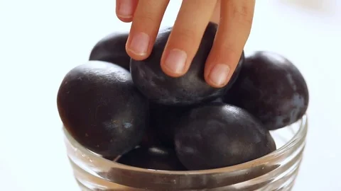 Hands taking plums from the vase Stock Footage 81249588