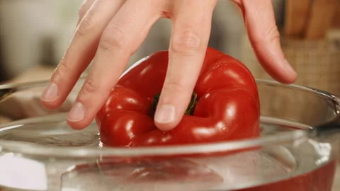 Hands taking red bell pepper from water in slow motion Stock Footage 152904317
