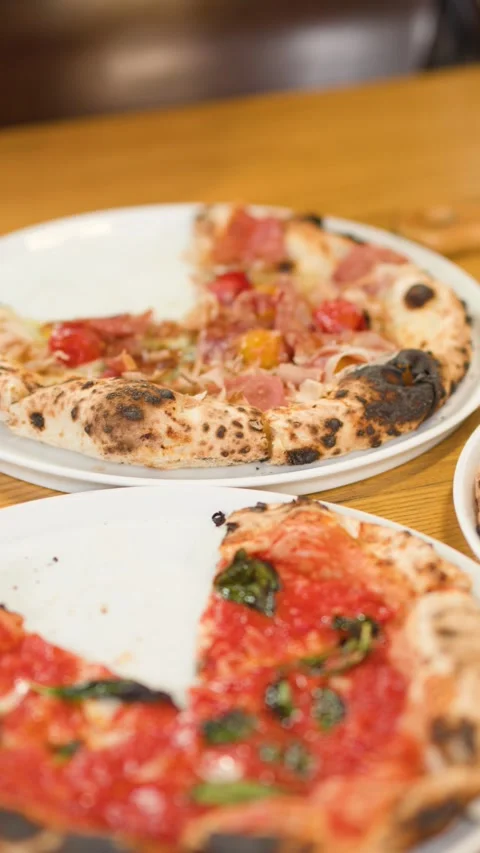 Hands Taking Slices of Neapolitan Pizza at a Restaurant Table 스톡 동영상 338374916