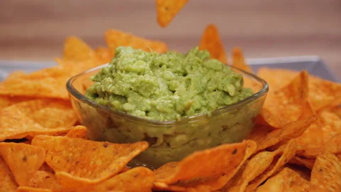 Hands taking tortilla chips from a plate - close up Video stock 151404596