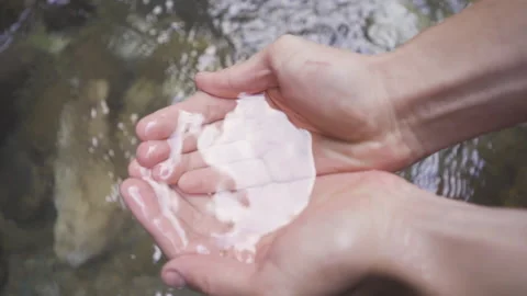Hands taking water from the stream. palming. Slow motion. Video stock 212437619